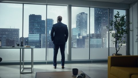 Thoughtful African-American Businessman in a Perfect Tailored Suit Standing in His Office Looking out of the Window on Big City. Successful CEO Planning His Investment Strategy for e-Commerce Startup