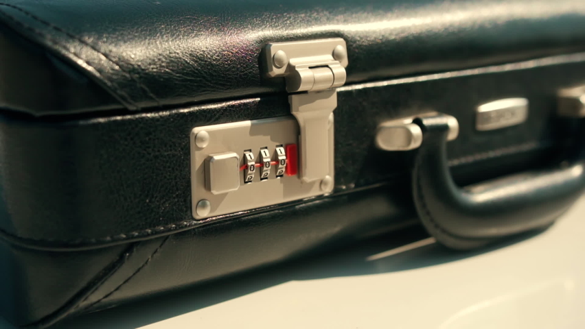 Caucasian man presses on a black briefcase on metal locks with a password with numbers and opens it. The case is full of money. Bundles of dollars in a suitcase. Financial fraud, illegal business Royalty-Free Stock Footage #1079128850