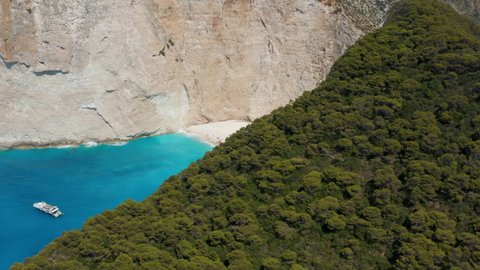 Aerial View Of Tourists And Boats In Navagio Beach With Shipwreck On A Sunny Summer Day In Greece. - reveal