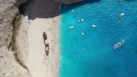 Famous Navagio Beach With Shipwreck - Boats Floating On Turquoise Water Of Coast Of Zakynthos In Greece. - aerial