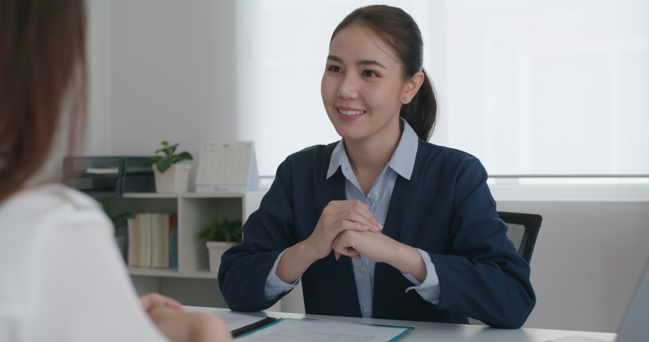 Asia woman real estate sale agent or trader advice sitting at lawyer office desk  smile trust talk in wealth service legal tax consult. HR people brief or coach for happy work plan in bank loan job.  | Shutterstock HD Video #1079131013