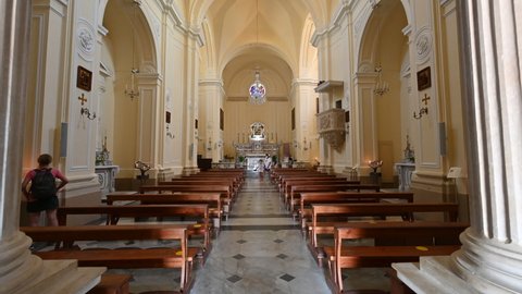 Santa maria di Leuca, Puglia, Italy. August 2021. Tilt footage of the nave of the Sanctuary of Santa Maria de Finibus Terrae. Some visitors move inside.