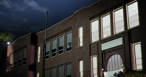 A night establishing shot of a typical small town two-story red brick school building. Room lights turn on and off. Day version available, ID 1031804537	