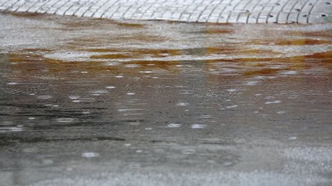 Rain falling in a water pool in the street, Tokyo, Japan