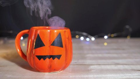 Witches brew in pumpkin mug at Halloween medium slow motion shot
