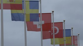 Ungraded: Flags of Slovenia, Spain, Sweden, Switzerland, Turkey, Ukraine and Belarus flags on flagpoles flutter in the wind against the sky. 