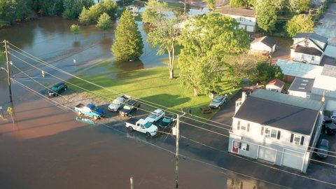 Aerial orbit of neighborhood community homes under water. Streets and roads flooded from hurricane rain storms.