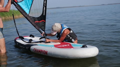 Ufa, Russia, August, 13, 2021, senior woman prepare to ride on windsurfing