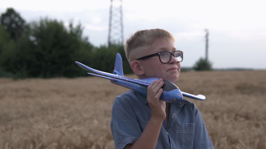 The guy is played with a toy airplane model on a wheat field.