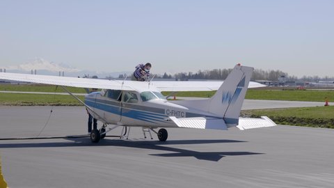 PITT MEADOWS , Canada - 05 21 2021: Crew Wearing Face Mask Refueling Light Aircraft Of Cessna 172 Plane.