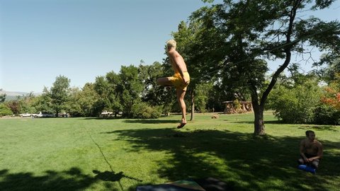 Boulder , Colorado , United States - 09 14 2020: Young Caucasian man stands up on a slackline in the park.
