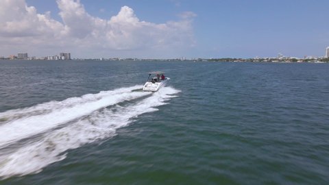 Florida , United States - 05 25 2021: Aerial view around friends driving a boat, in Florida, USA - circling, drone shot
