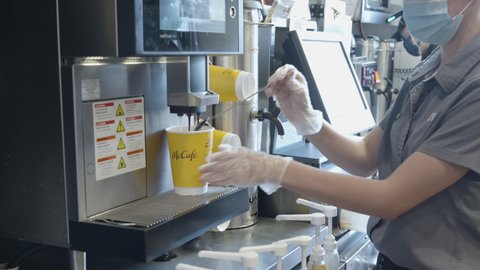 Cleveland , OH , United States - 09 25 2020: McDonald's employee prepares a caffe latte coffee drink during COVID-19 pandemic slow motion