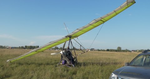 Gliding, training flights. The hang glider is on the field airfield. Shooting with hands (hand-helding) Siberia.