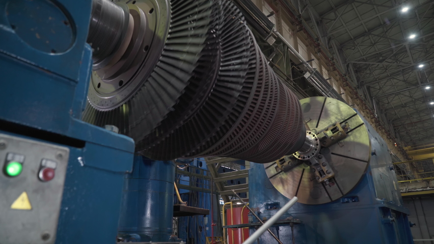 Manufacturing of Heavy Duty Gas Turbines. Rotating Compressor Component Fixed on a Big Testing Machine. Machining Process. Operator supervising the Work. Inside a Production Facility. Heavy industry. Royalty-Free Stock Footage #1079171177