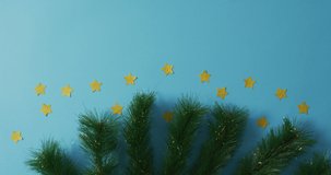 Fir tree branches with stars and copy space on blue background. christmas, tradition and celebration concept video.