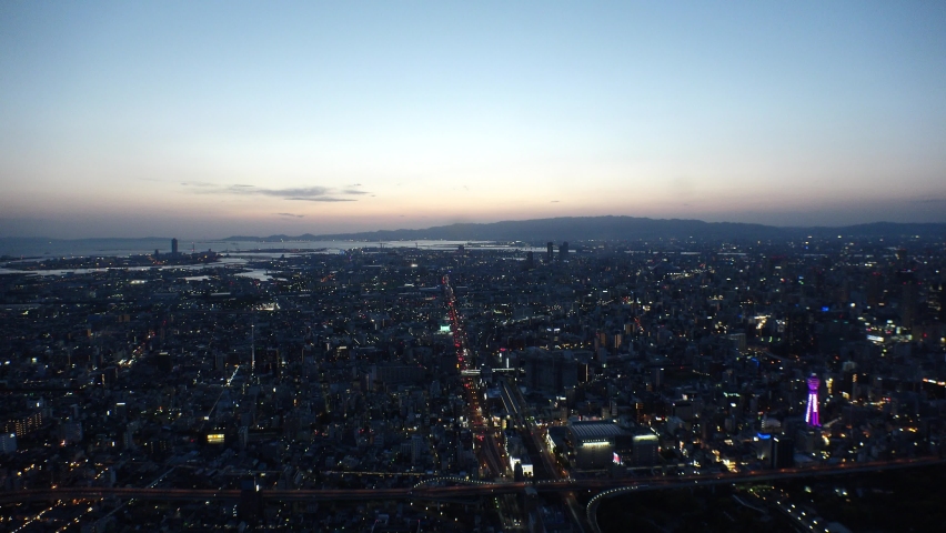 OSAKA, JAPAN : Aerial high angle view of CITYSCAPE of OSAKA at night. View of buildings and street traffic around Osaka bay and Kobe port. Wide view real time shot.