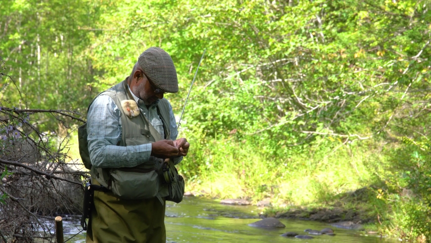 A mature fly-fisherman on a trout stream in the early autumn