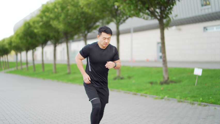 young asian runner athlete with muscle pain. Man massaging Stretching, trauma injury while jogging outdoors. Fitness male sprain severe pain stretch pull. Leg muscle cramp calf sport Royalty-Free Stock Footage #1079191247