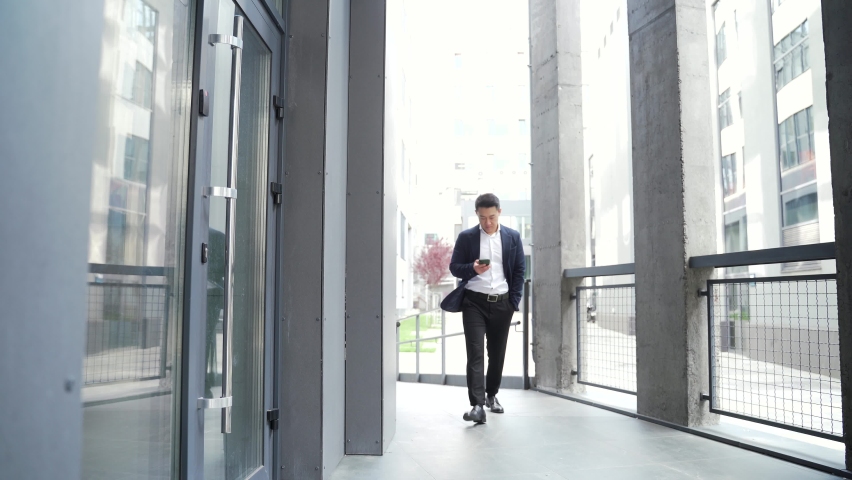 male asian businessman unlocking door using mobile phone application. Unlocks a modern office building. Scanning open smartphone with mock up screen app. smart electronic locks with keyless access Royalty-Free Stock Footage #1079191274