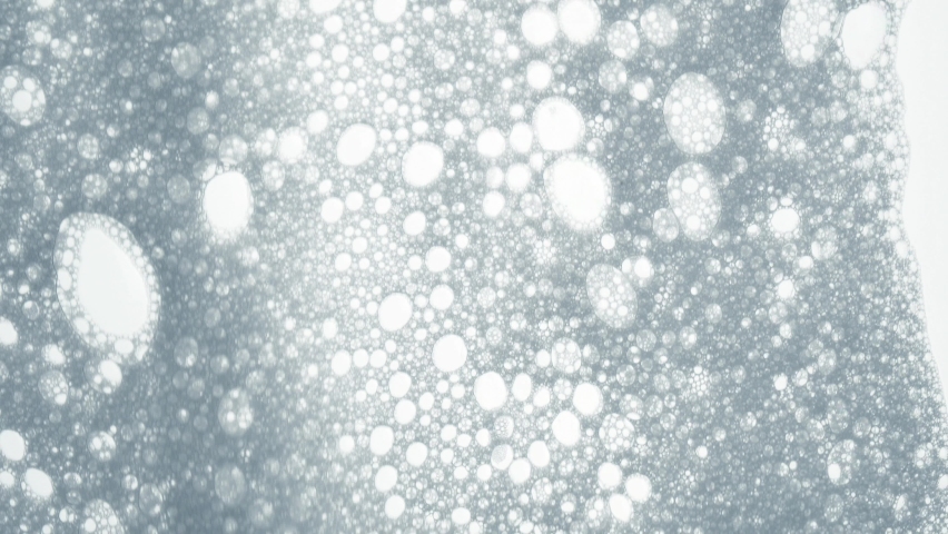 Bubble slow motion. Foam bubbles abstract. White foam with bubbles texture, soap, detergent or shampoo or cleanser surface, macro shot. 4k video 