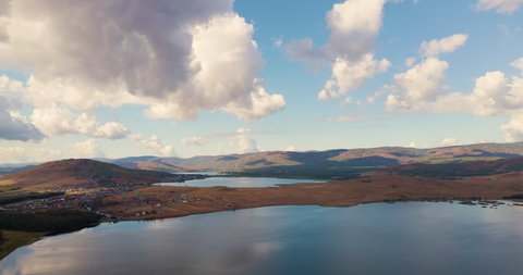 Three lakes in the mountains at sunrise. Aerial drone view. Beautiful clouds in the blue sky and view of hills and mountains. Autumn landscape in South Ural, Bashkortostan, Russia.
