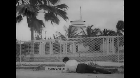 CIRCA 1935 - A man paints "Roosevelt Boulevard" onto a curb in Key West, Florida.