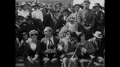 CIRCA 1914 - In this silent film, a woman (Charlie Chaplin in drag) fights off multiple men trying to stop her from interrupting a military parade.