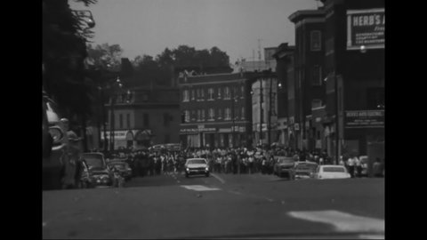 CIRCA 1960s - People in a Hispanic neighborhood watch a Catholic parade pass by.
