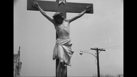 CIRCA 1960s - A crucifix is held aloft during a parade in a Hispanic neighborhood.