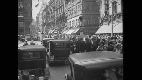 CIRCA 1930s - Cars, pedestrians, and streetcars crowd a busy intersection in Prague, Czechoslovakia.