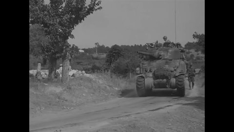 CIRCA 1944 - American soldiers drive M-4 tanks into Le May, France.