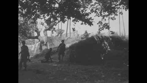 CIRCA 1944 - American paratroopers approach Le May, France on foot and in tanks.