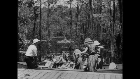 CIRCA 1946 - Tourists enjoy a boat tour of Georgia's Okefenokee swamp.
