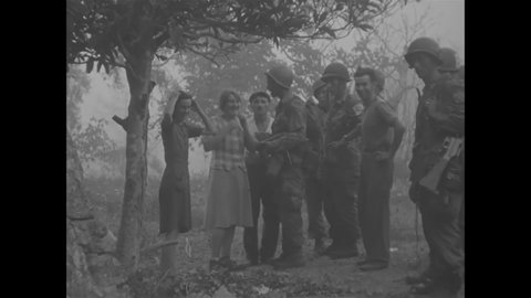 CIRCA 1944 - French civilians give directions to American paratroopers near Le May.