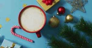 Video of christmas decorations with coffee and presents on blue background. christmas, tradition and celebration concept.