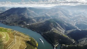 Panoramic shot of vineyards growing on mountains of Douro vallay, Peso da Regua, Vila Real, Portugal, Europe. Scenery view of tourist boat floating on Douro river in picturesque landscape, 4k footage