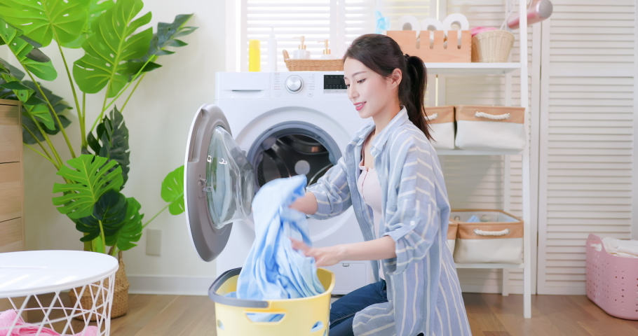 Asian housewife push clothes in washing machine happily and setting procedure at home | Shutterstock HD Video #1079214404