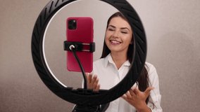 Young woman recording smart phone vlog. Influencer marketing in social media concept, beauty blogger live broadcasting spanish language teacher tutorial on social media. Vlogger recording vlog video