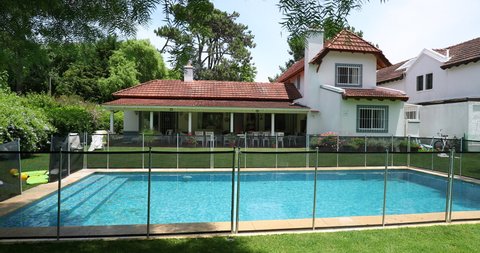 House exterior during sunny day. Residential home with swimming pool