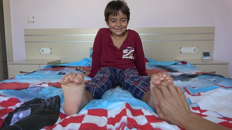 4K Ticklish child giggles when mothers hand tickles his soles
