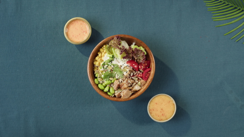 Putting cooked poke bowls on table top view. Traditional Hawaiian dishes served with sliced vegetables, seafood and greenery. Healthy vegetarian food. Asian vegan raw meal. Royalty-Free Stock Footage #1079231684