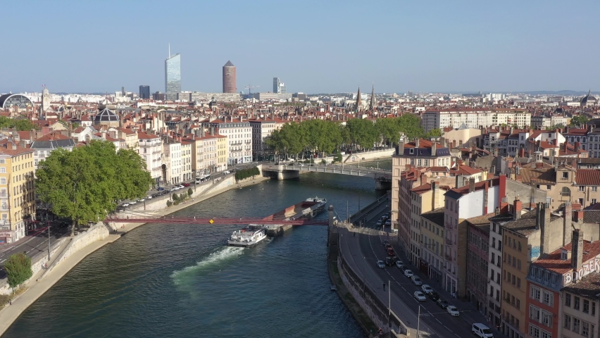 France, Lyon, barge on the Saone river passing under the bridges of the historic old town. Drone aerial view.