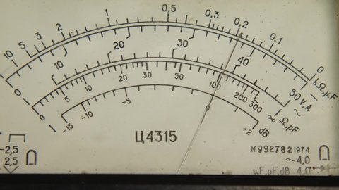 Close-up of a hand running across the dial on a Soviet C4315 multimeter. The device is designed to measure DC and AC current, voltage and resistance