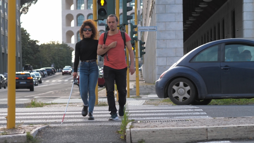 help, support - young blind woman crosses the street arm in arm with a friend Royalty-Free Stock Footage #1079244665