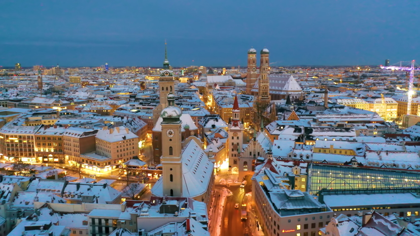 Aerial view of Munich City Germany at winter with snow, Cathedral Church of Our Lady (Frauenkirche) in munich old town Marienplatz. Munchen Skyline aerial view at morning. Munich night winter skyline. Royalty-Free Stock Footage #1079246213