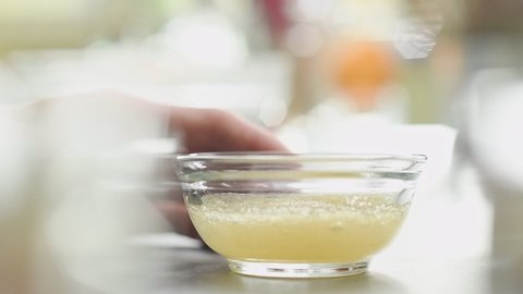 Confectioner preparing gelatine in a glass bowl.