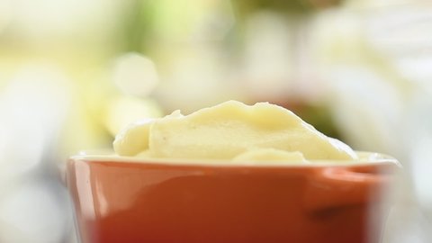 The cook serves mashed potato into a bowl.