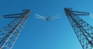 Zoom-out view of two electric power transmission towers. Cinema 4K 60fps video
