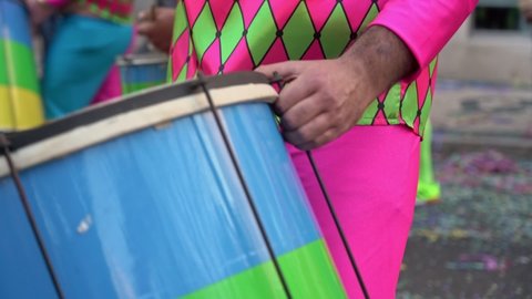 A group of drummers playing rhythmic music during the parade at the carnival. Dressed in colorful traditional costumes.